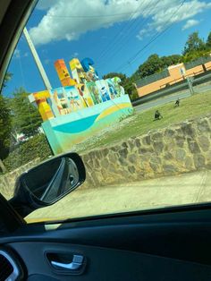 a view from the inside of a car looking at an amusement park