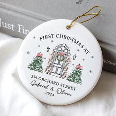 a first christmas ornament hanging from a book