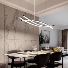 a dining room table and chairs with lights hanging from it's ceiling above them