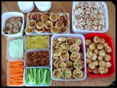 there are many different foods in trays on the table