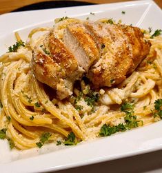 a white plate topped with pasta and chicken