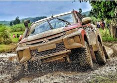 an orange truck driving through mud on a dirt road