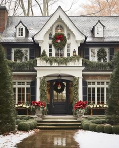 a house decorated for christmas with wreaths and poinsettis