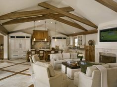 a living room filled with furniture and a fire place in the middle of a kitchen