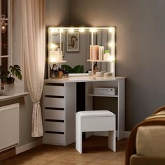 a white vanity with lights on it and a stool in front of the mirror that is lit up