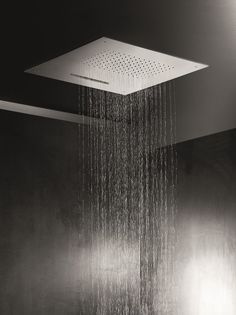 a shower head with water running down it's side in a black and white photo