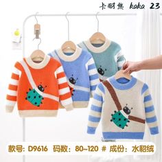 children's sweaters are hanging on the clothes rack