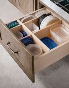 an open drawer in a kitchen filled with dishes