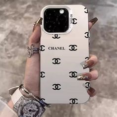 a woman holding up her chanel phone case