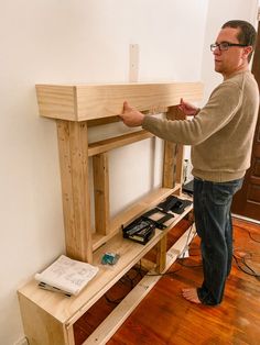 a man standing next to a wooden shelf