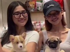 two women holding small dogs in their arms