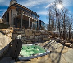 a large hot tub sitting in front of a stone wall next to a building with windows