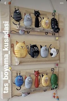 three wooden pegs with cats on them hanging from the wall