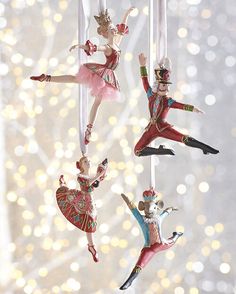 three ornaments are hanging from strings in the shape of ballet dancers