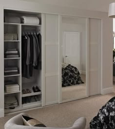 a bedroom with white closets and black bedding