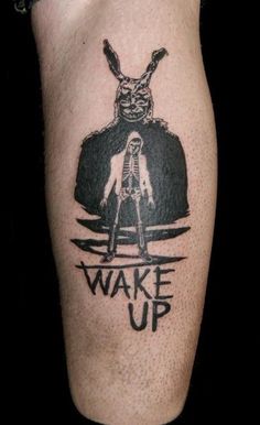 a person with a tattoo on their leg that says wake up and an image of a rabbit