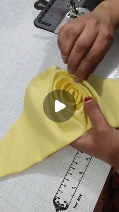 someone is making a yellow tie out of fabric