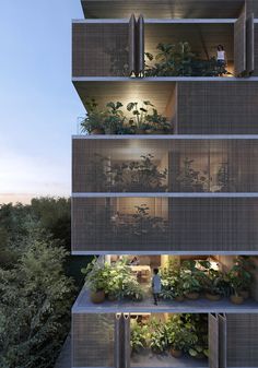 a tall building with lots of plants growing on the balconies