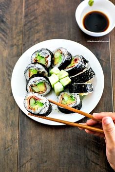 sushi with cucumber and avocado on a white plate next to a cup of coffee