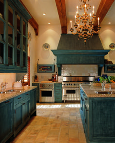 a large kitchen with blue cabinets and an island in front of the stove top oven