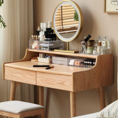 a wooden desk with a mirror and various items on it in front of a window