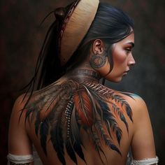 the back of a woman's head with tattoos and feathers on her upper body