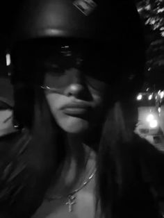 a woman wearing a helmet and sunglasses on the street