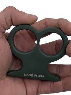 a hand holding a green pair of scissors in it's right hand, with the words made in usa written on it