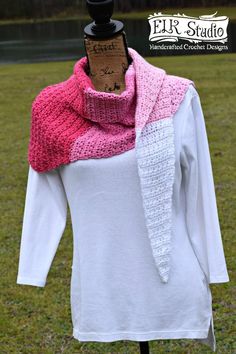 a white shirt and pink scarf sitting on top of a wooden mannequin stand