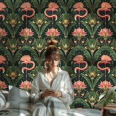 a woman sitting on top of a bed next to a wallpaper covered in pink flamingos