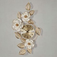 a gold and white clock with flowers on it