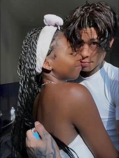 a man and woman kissing each other in front of a mirror