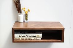 a wooden shelf with books and vases on it