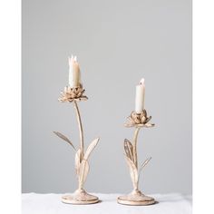 two white candles sitting on top of each other