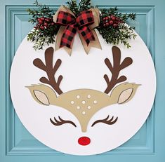 a paper plate with reindeer's head and red nose is hanging on a blue door