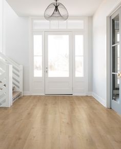 an empty room with white walls and wood flooring is pictured in this image from the front door