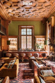 a living room filled with lots of furniture and a bar in the back drop ceiling