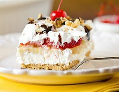 a piece of cake with whipped cream and cherries is on a plate next to a fork