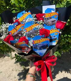 a person holding a bouquet of hot wheels flowers