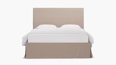 a bed with a beige headboard and white sheets