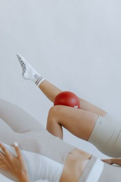 a woman laying on top of a bed with her leg wrapped around an object in the air