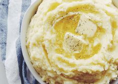 a bowl filled with mashed potatoes on top of a blue and white towel