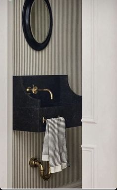 a bathroom with a black sink and gold faucet on the wall above it