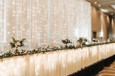 the long table is decorated with white flowers and greenery