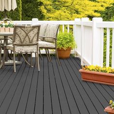 an outdoor table and chairs on a deck with potted plants in the foreground