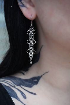 A dainty but detailed pair of drop chain earrings, made using a chain weaving method to create a beautiful floral chain detail. This chain is hand made using stainless steel materials to ensure comfort as well as longevity, due to the metal being anti tarnish and hard wearing. The earrings are teardrop shaped huggie hoops with lever back fastening made with high quality stainless steel. Silver Stainless Steel Earrings With Adjustable Chain, Dainty Sterling Silver Chain Earrings, Chain Mail Jewelry, Chain Maille Patterns Tutorials, Chainmail Accessories, Chain Mail Earrings, Chainmaille Jewelry Patterns, Chain Maille Patterns, Chainmail Earrings