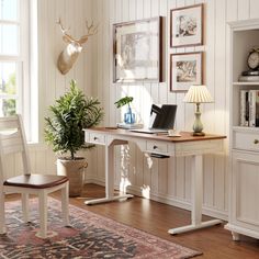 a white desk with a laptop on top of it next to a chair and lamp