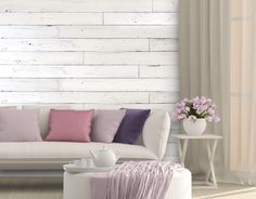 a white couch with pink and purple pillows