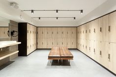 an empty room with wooden lockers and a bench