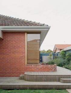 a brick house with wooden shutters and steps leading up to the front door area